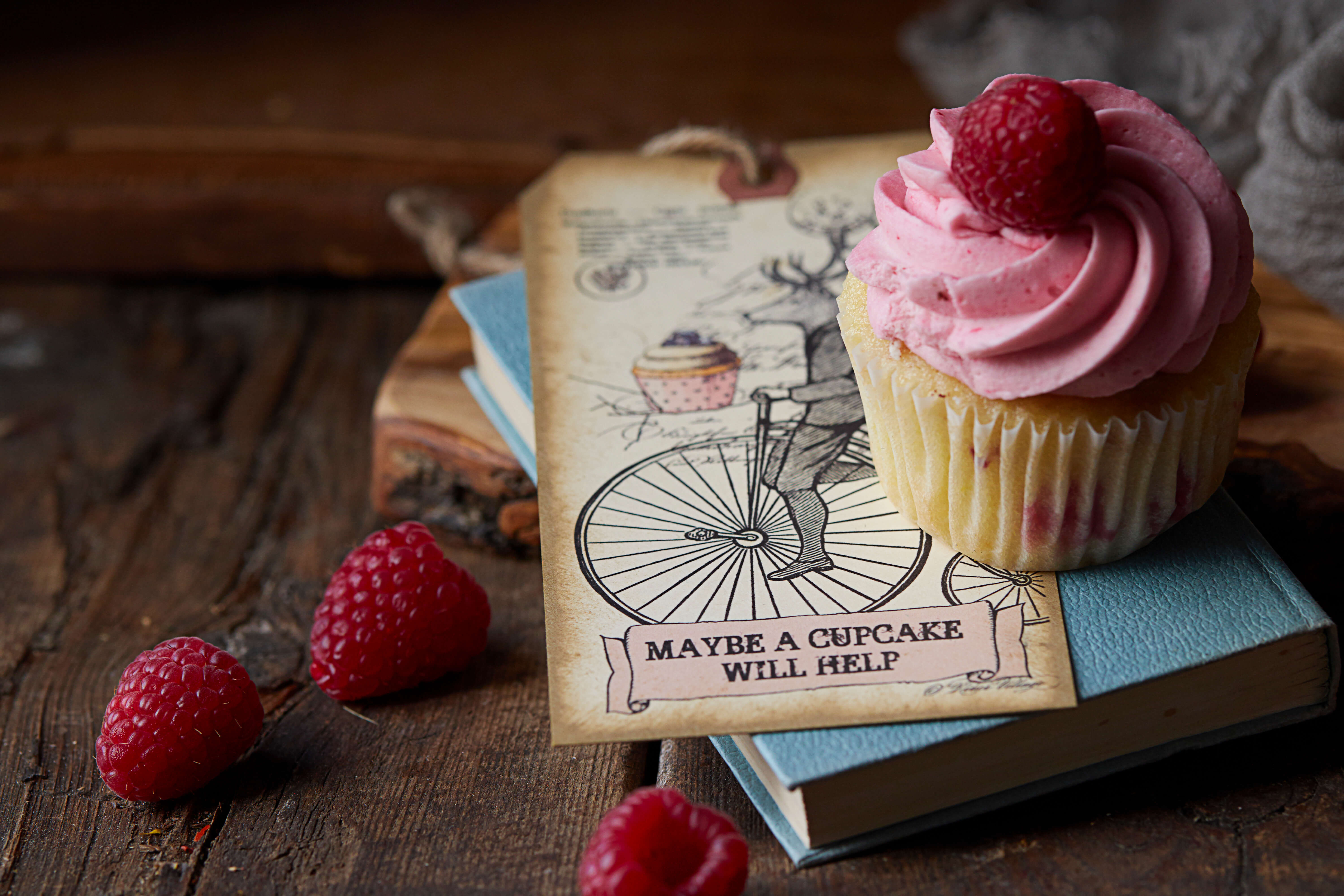 Raspberry Twist Cupcakes decorated with raspberries and a sign which says maybe a cupcake with help
